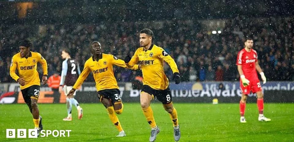Player celebrating goal in rain during match