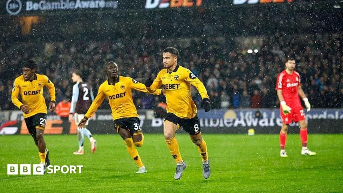 Player celebrating goal in rain during match