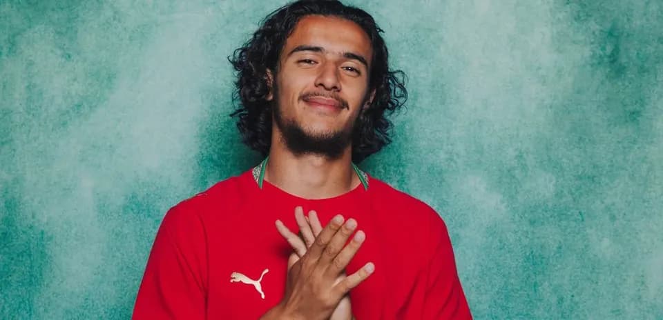 Player posing with hands together in red jersey