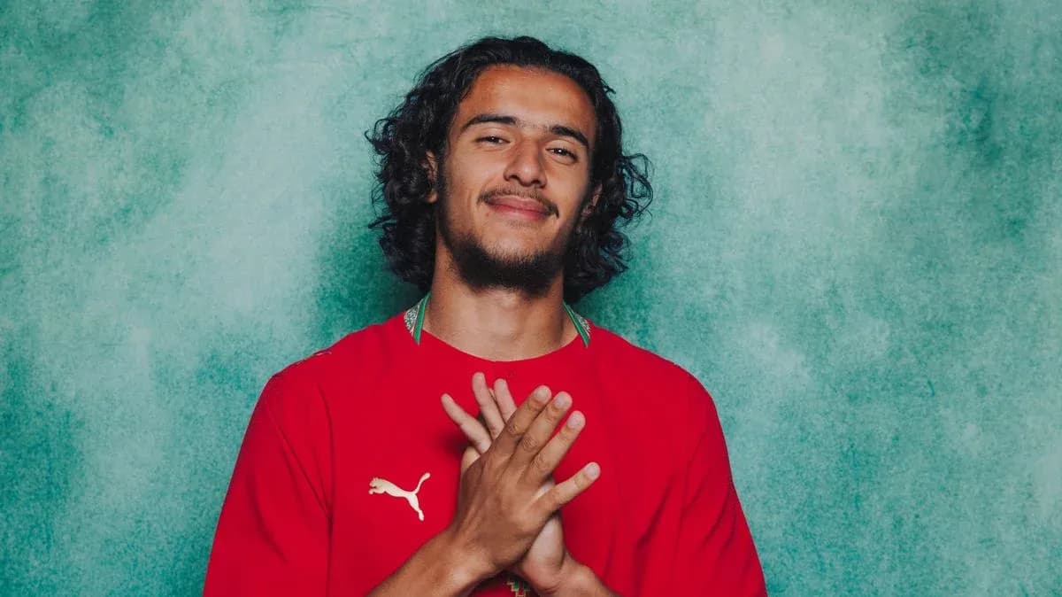 Player posing with hands together in red jersey