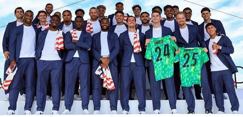 Soccer team posing in suits with jerseys