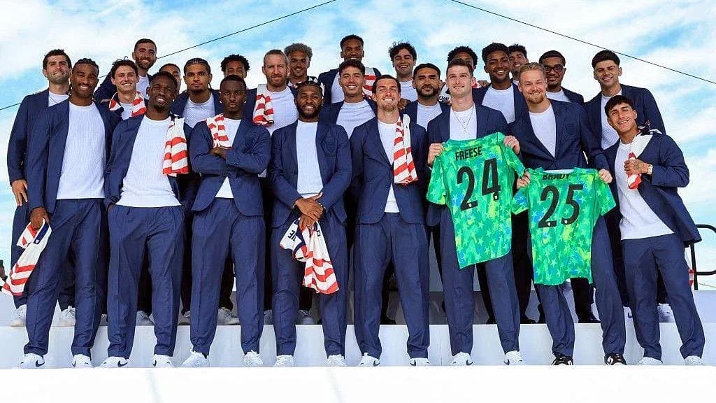 Soccer team posing in suits with jerseys