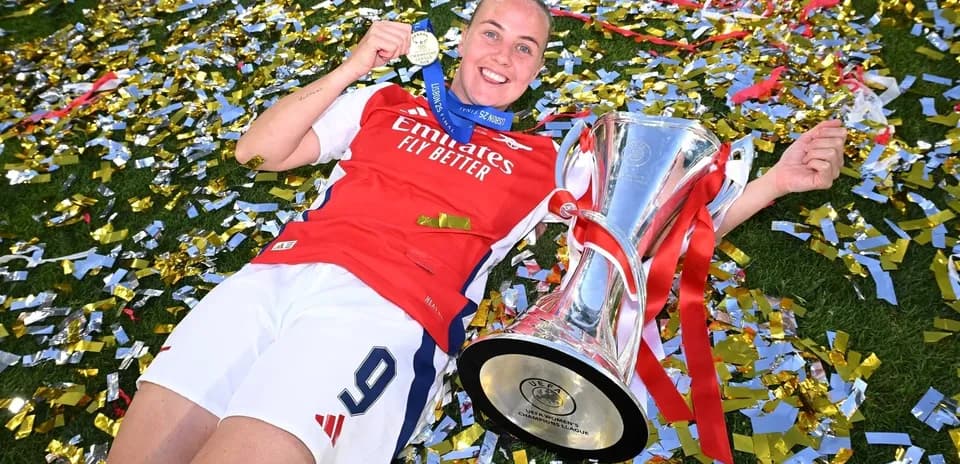 Player celebrating with trophy and medal on field