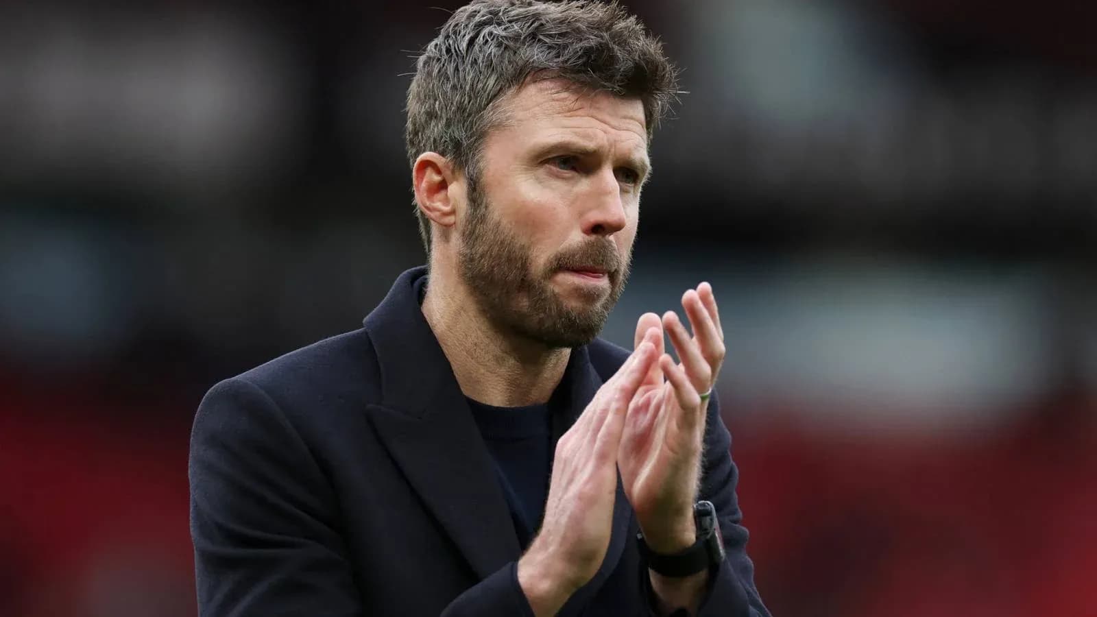 Coach applauding on the pitch during match