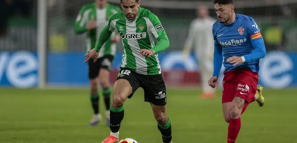 Real Betis player dribbling against Elche opponent