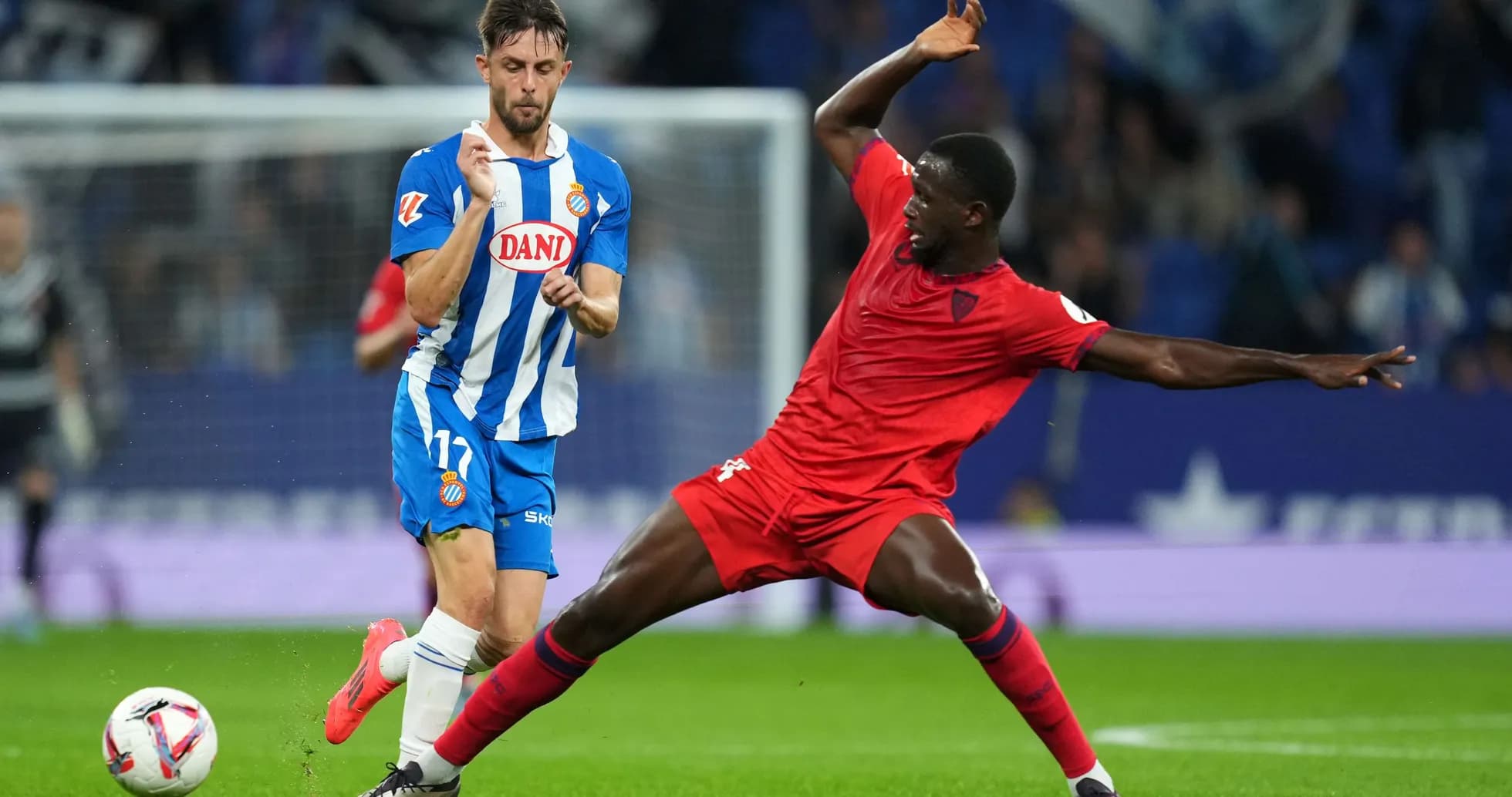 Espanyol player dribbling past Sevilla defender