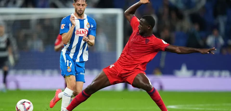 Espanyol player dribbling past Sevilla defender
