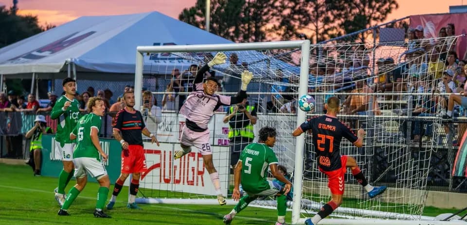 Goalkeeper attempting to save a shot on goal