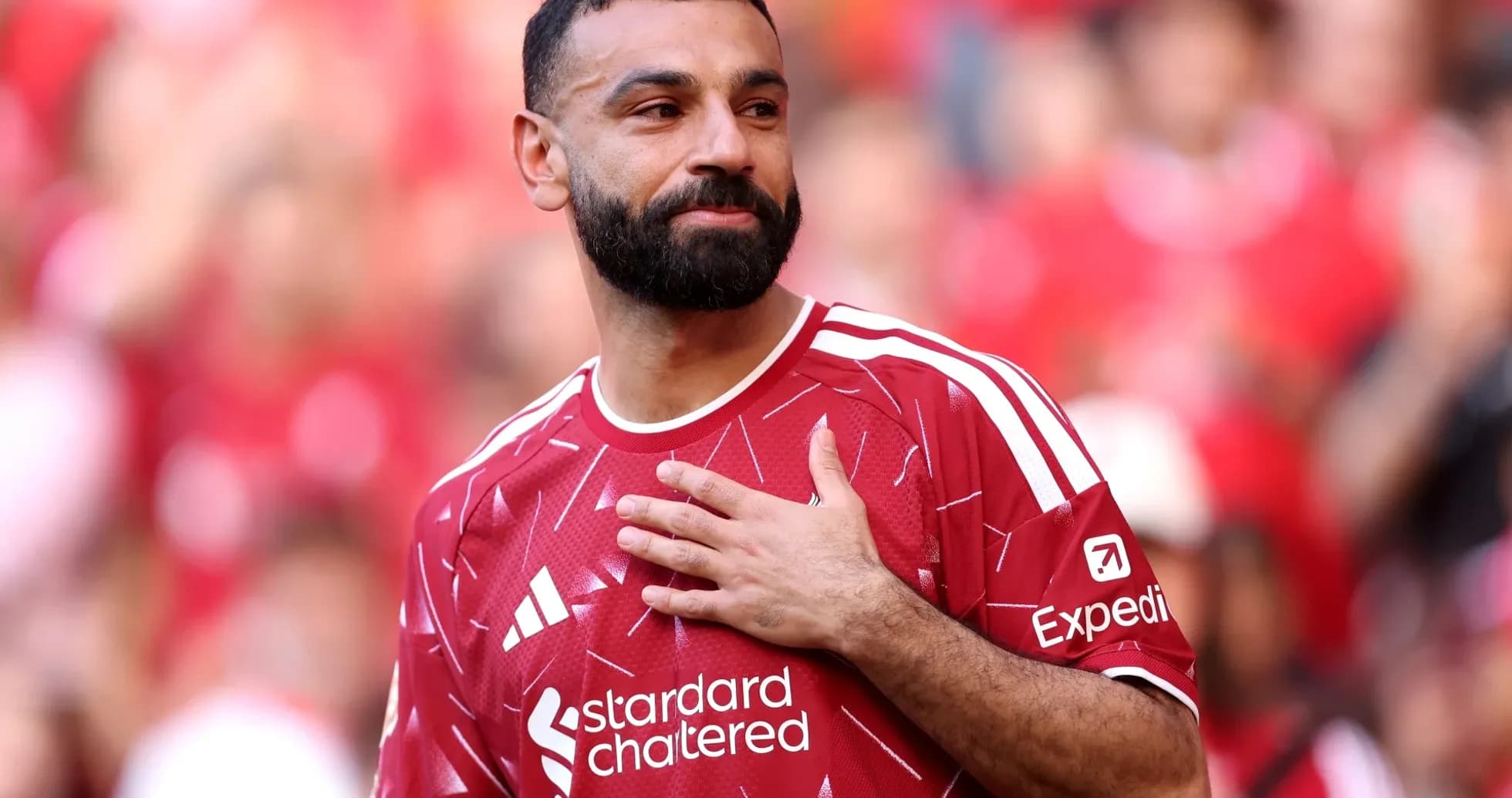 Player in red jersey gestures to crowd during match