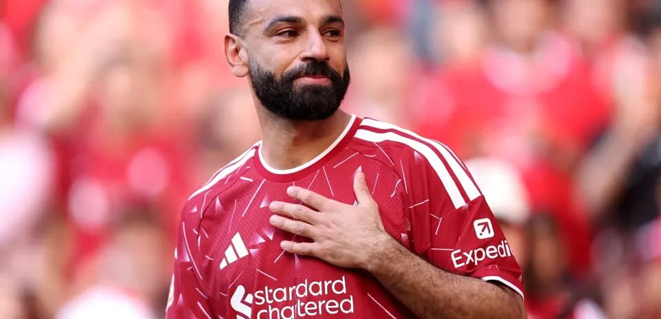 Player in red jersey gestures to crowd during match