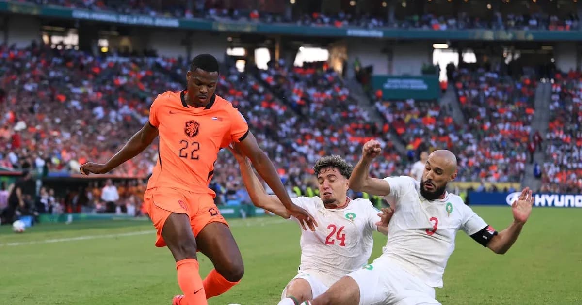 Player in orange jersey evading two defenders during match