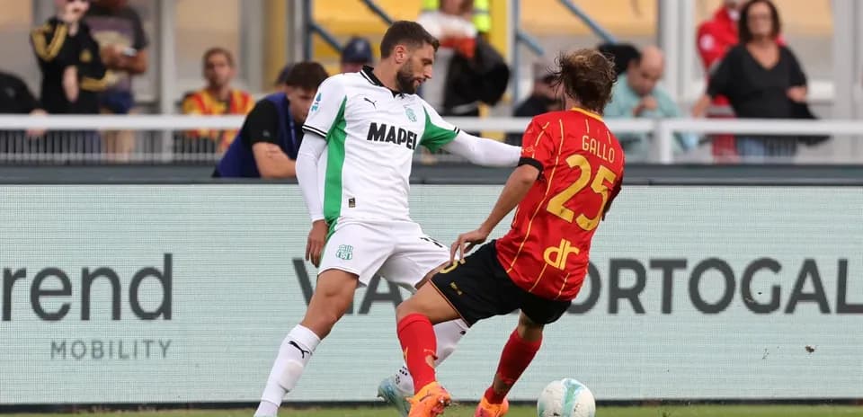Sassuolo player challenges Lecce opponent for the ball
