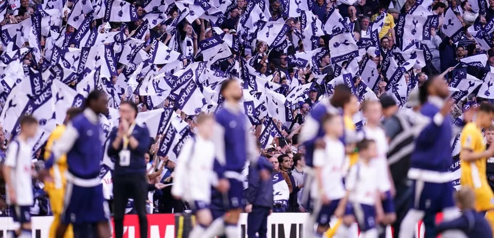 Fans waving flags during a Tottenham match