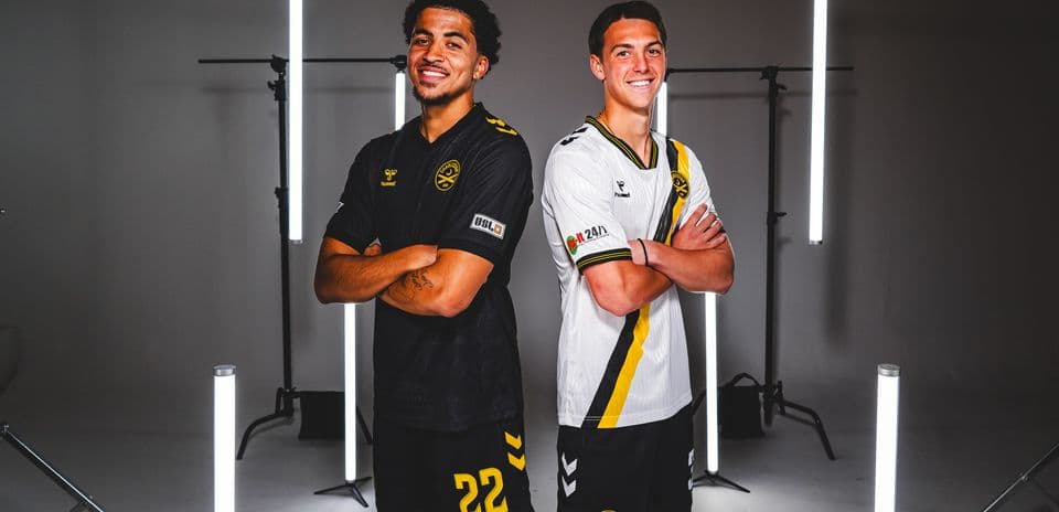 Two players in team jerseys posing together