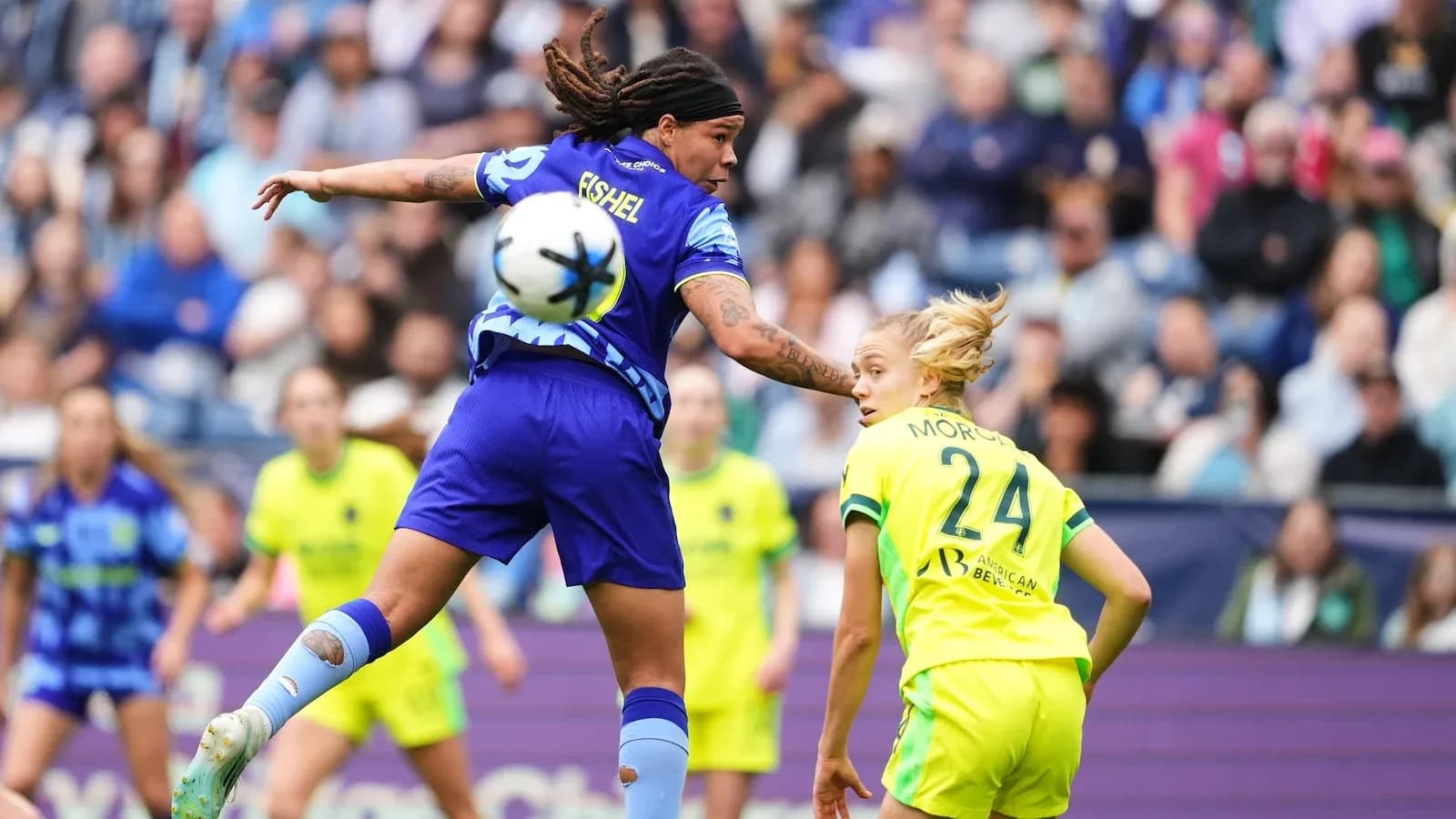 Two players competing for the ball in NWSL match