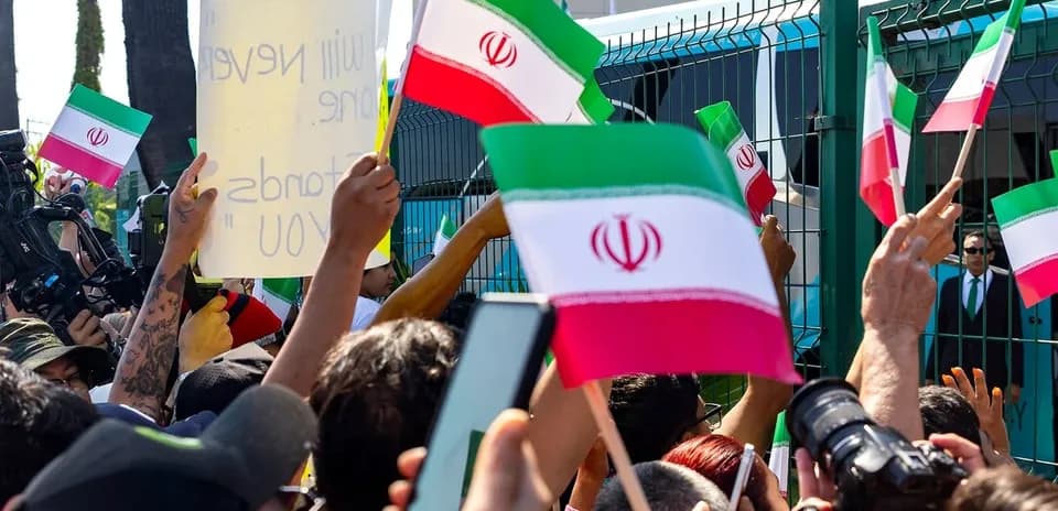 Crowd holding Iranian flags during a protest