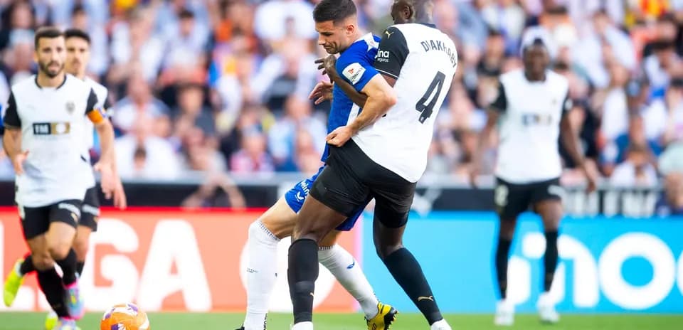 Athletic Club player challenged by Valencia defender
