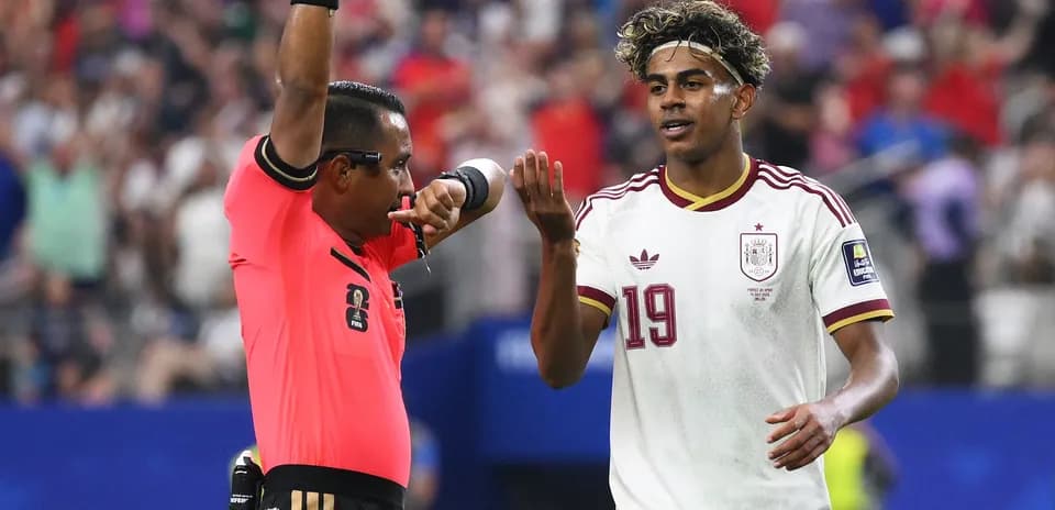 Referee signaling player during soccer match