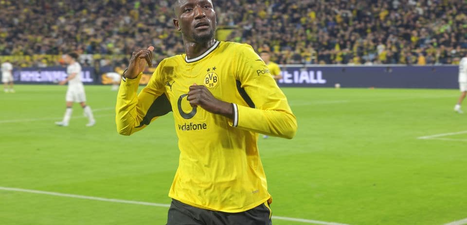 Player celebrating in Borussia Dortmund jersey on pitch