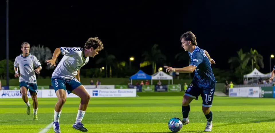 Two players competing for the ball in football