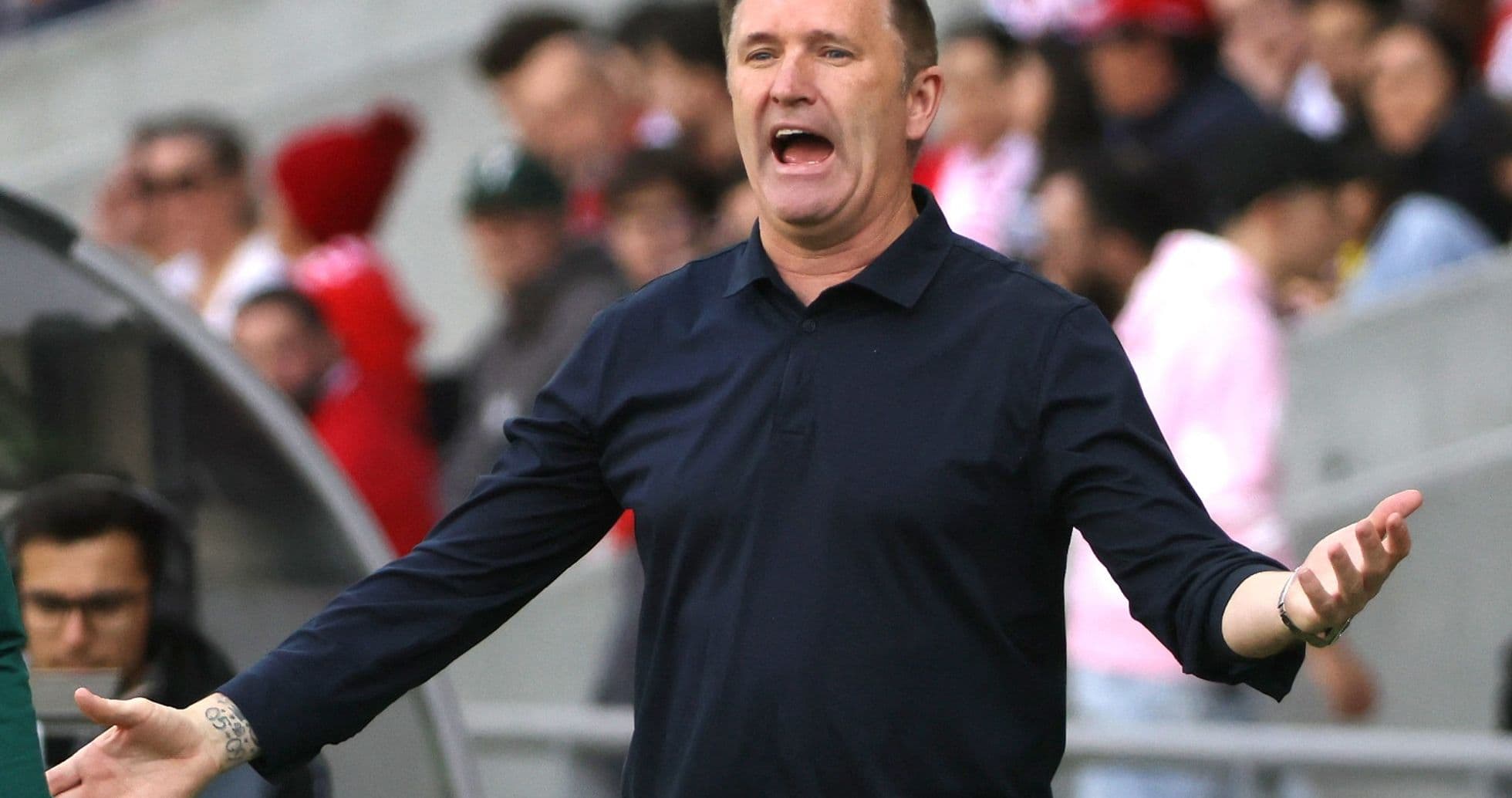 Coach gesturing passionately on the sidelines