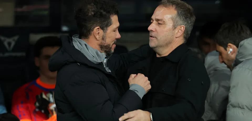 Two coaches greeting each other on the sidelines