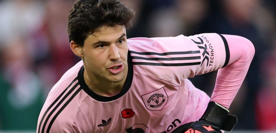 Goalkeeper in pink kit preparing for action