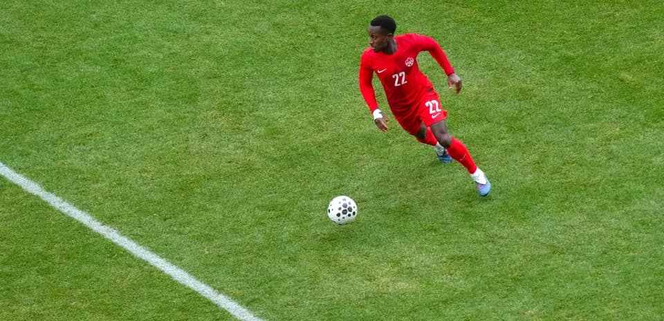 Player in red jersey dribbling the ball