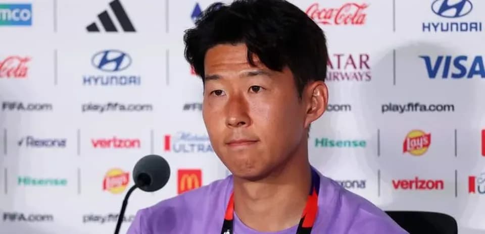 Player at press conference with sponsor logos behind