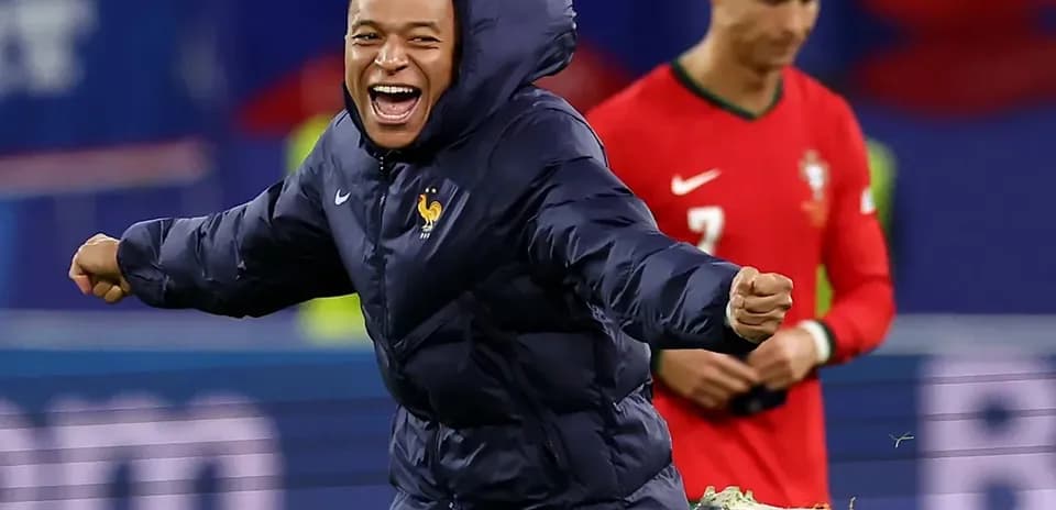 Player in blue jacket celebrating on the pitch