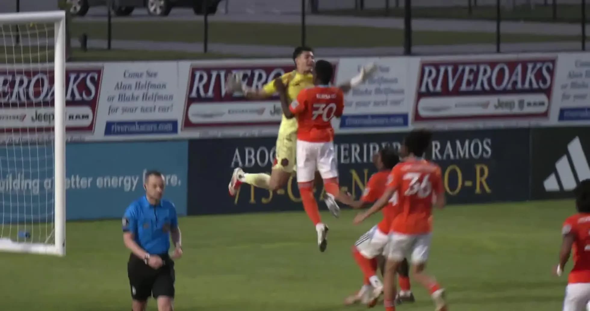 Goalkeeper jumping for the ball during match