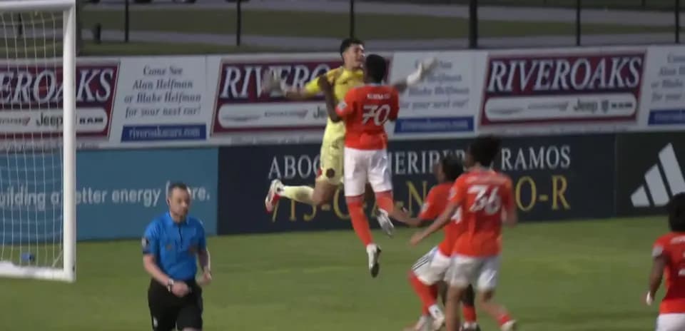 Goalkeeper jumping for the ball during match