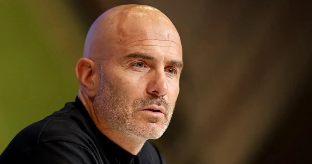 Manager speaking at press conference with serious expression