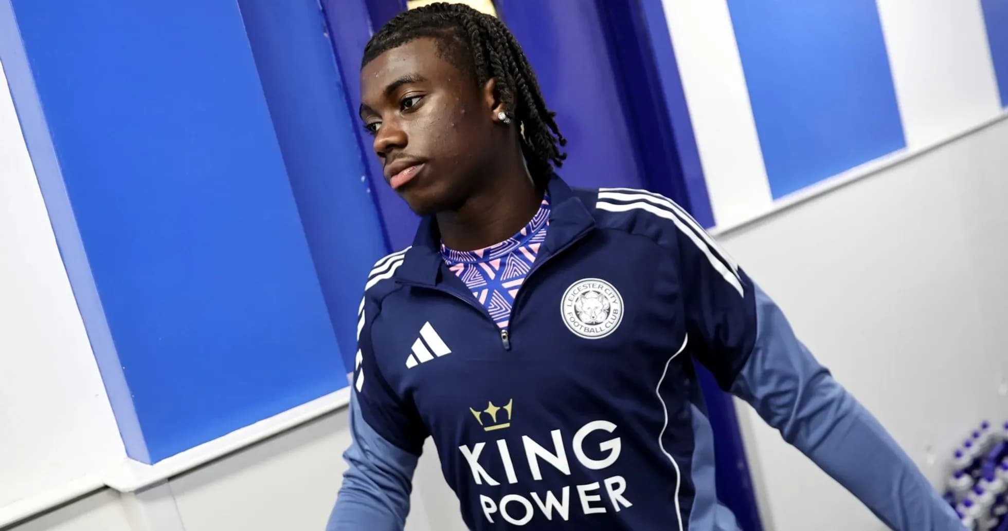 Player in Leicester City training kit walking indoors