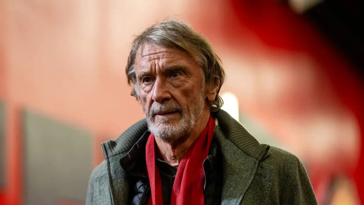Man with gray hair wearing a coat and scarf