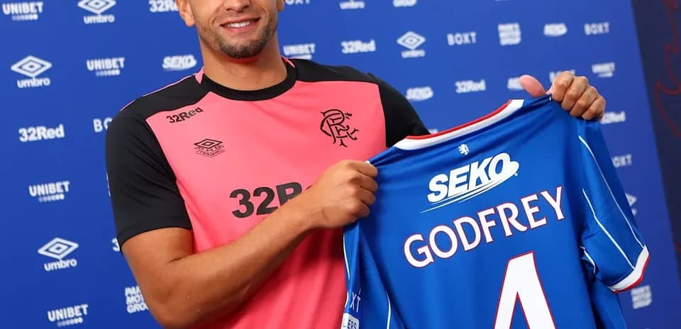 Player holding new jersey at signing event