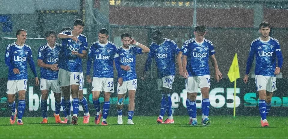 Como players celebrating in heavy rain during match