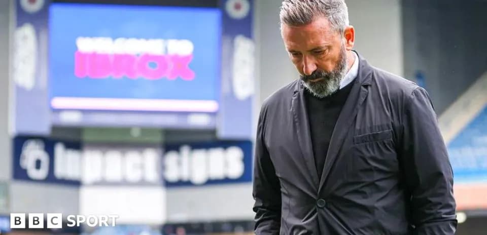 Coach walking with head down at Ibrox Stadium