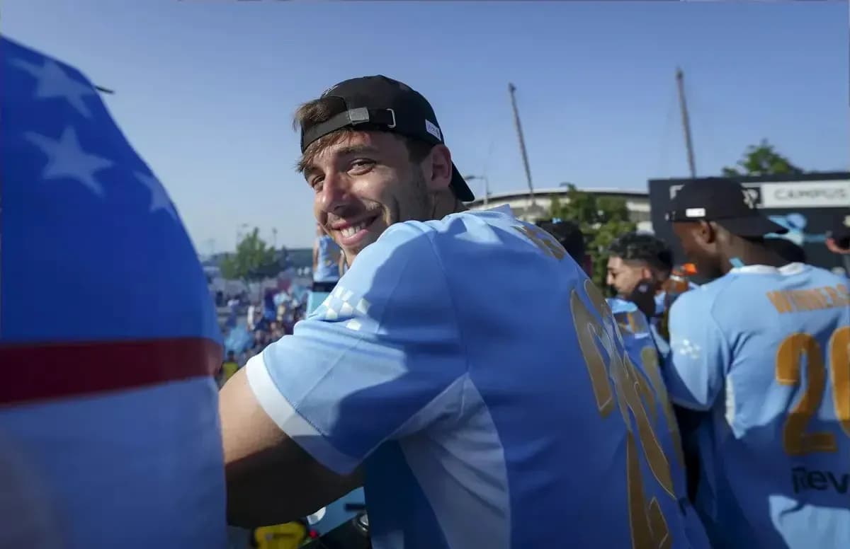 Player smiling in light blue jersey at celebration