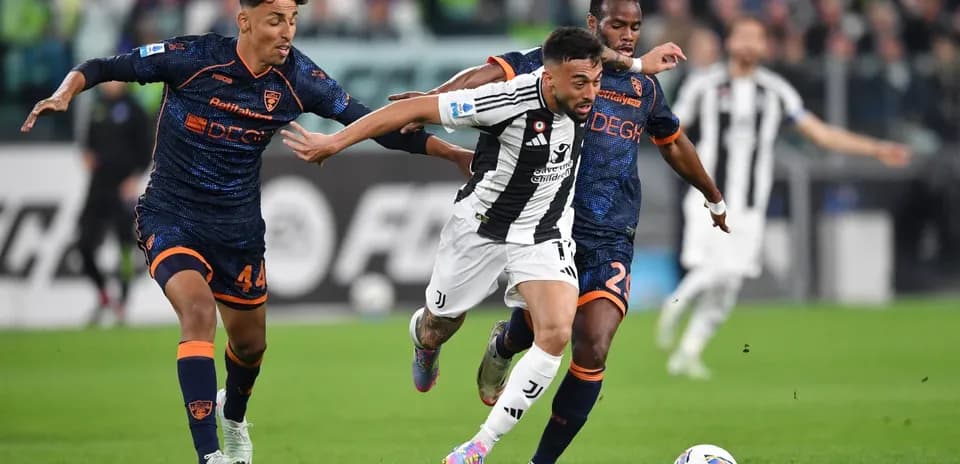 Juventus player dribbling against Lecce defenders