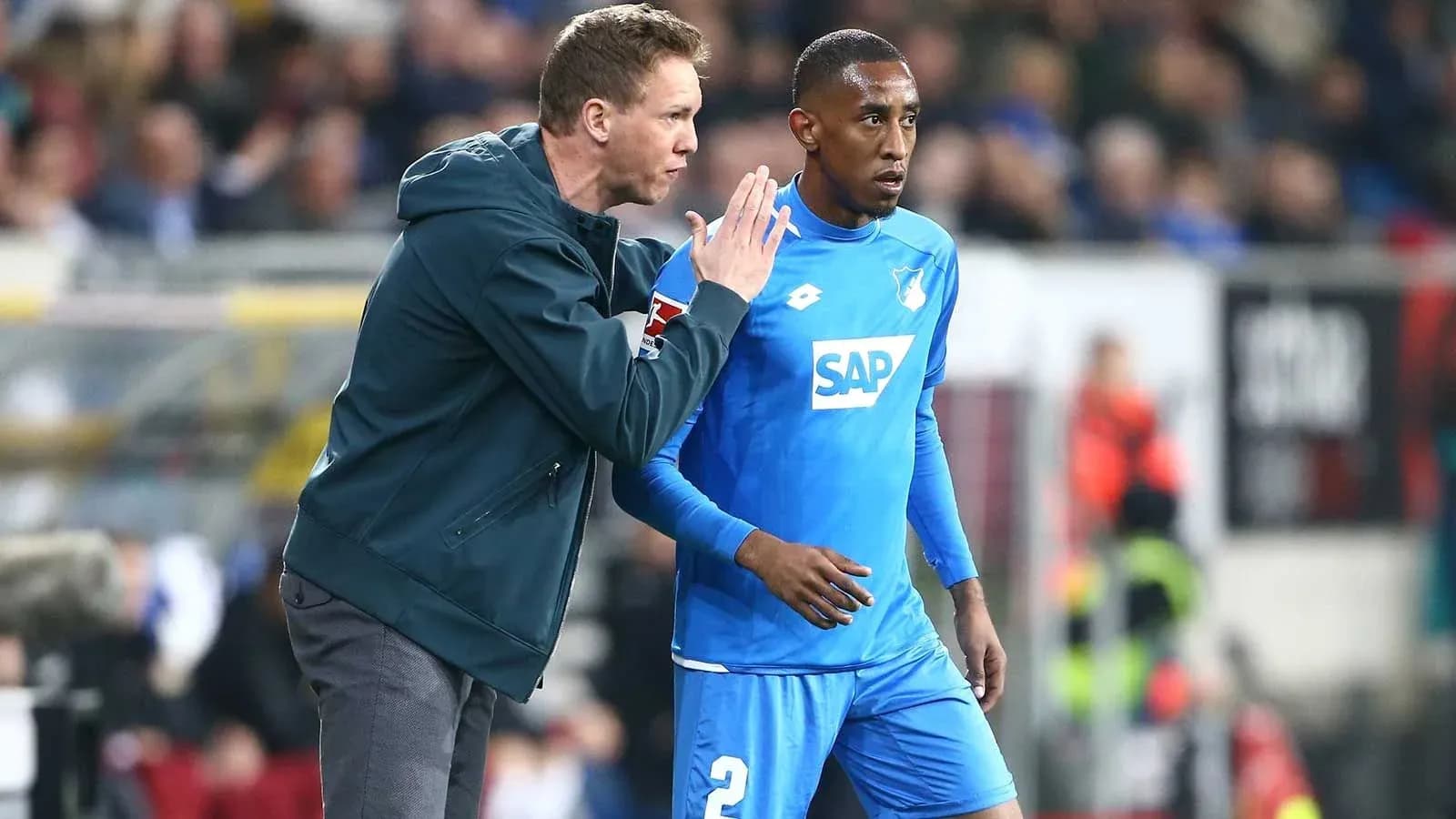 Coach giving instructions to player on the sidelines