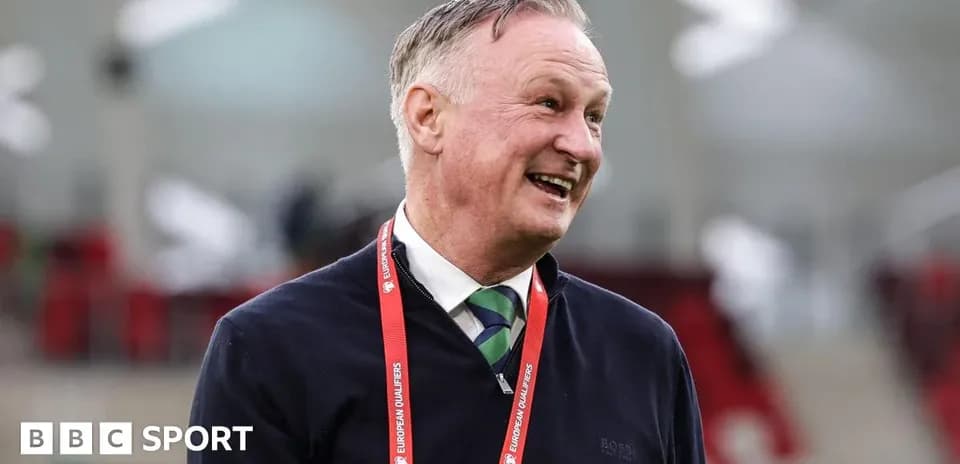 Man smiling in a stadium with lanyard