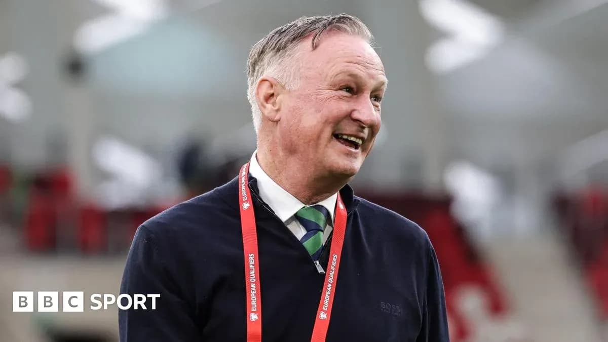 Man smiling in a stadium with lanyard