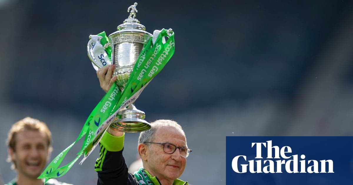 Coach holding trophy with green ribbons aloft