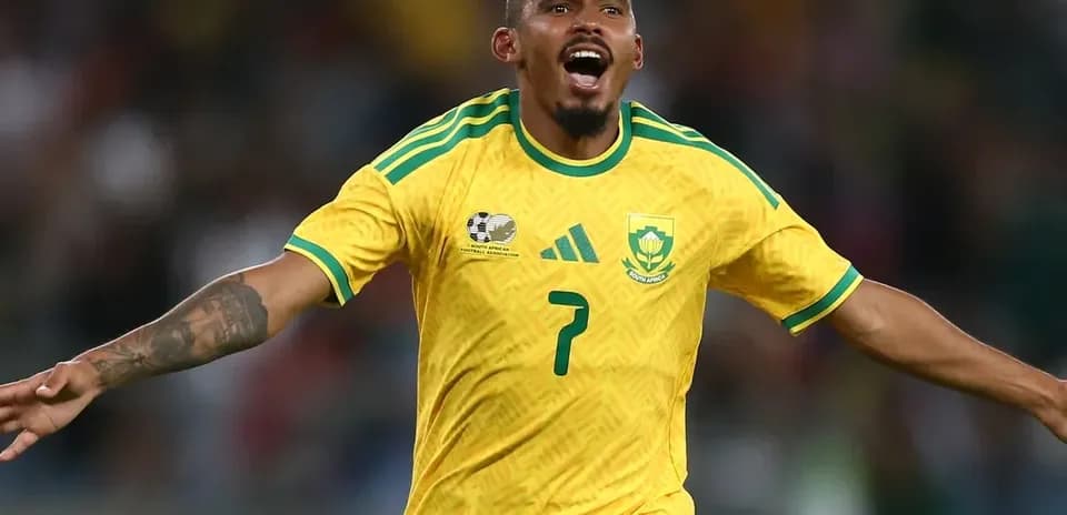 Player celebrating a goal in yellow South Africa kit