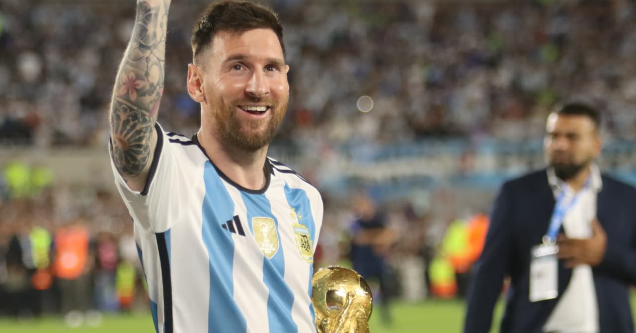 Player celebrating with trophy in stadium
