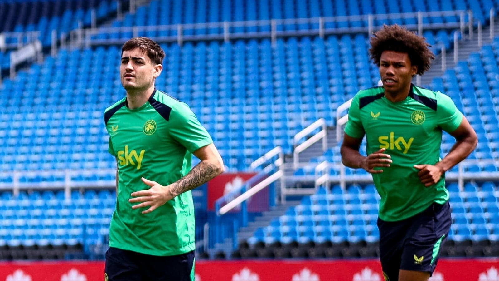 Two players jogging during training session on pitch