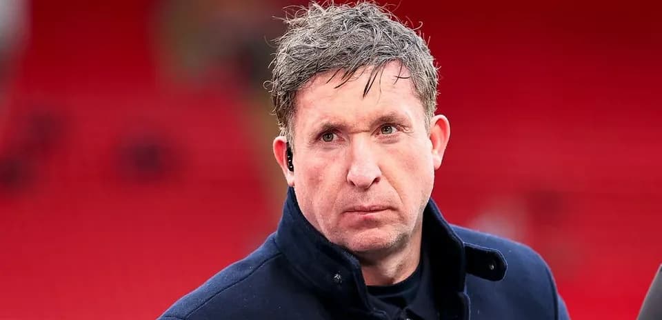 Man in coat at stadium with red background