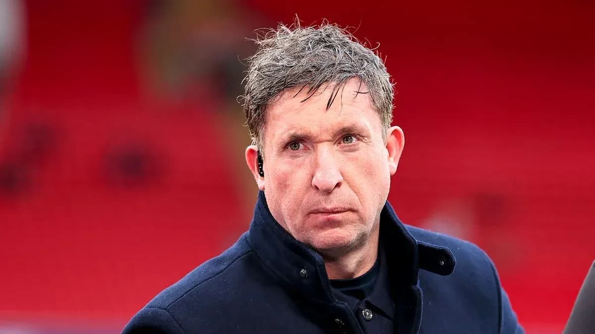Man in coat at stadium with red background