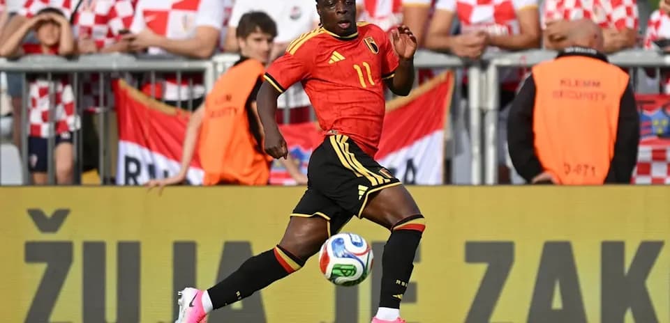Player in red jersey running with soccer ball